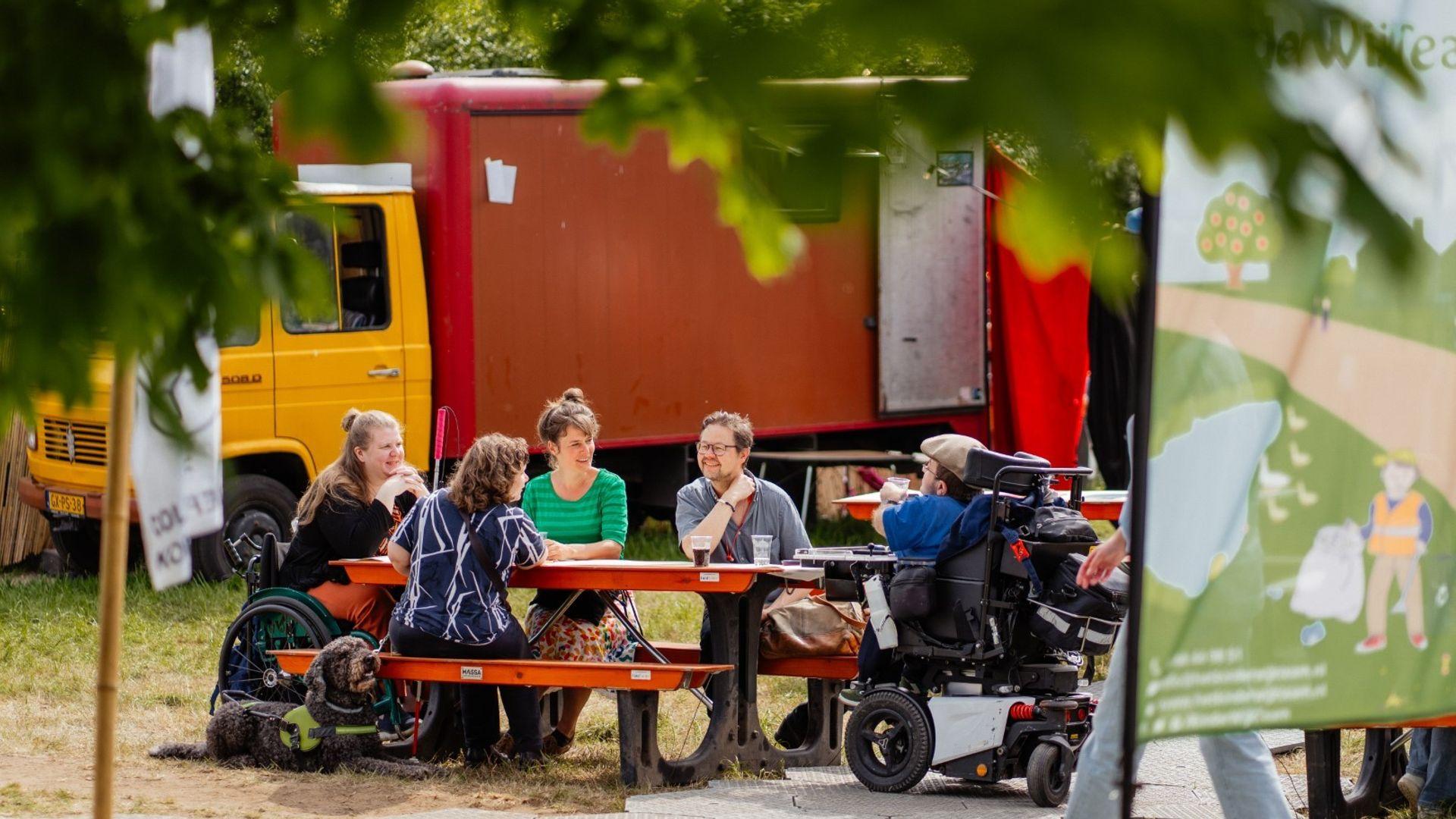 Bezoekers op een festival aan een tafel.